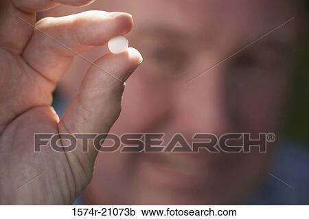 Close-up of a mature man showing a pill View Large Photo Image Stock Image - Close-up of a mature man showing a pill. Fotosearch