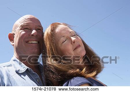Close-up of a mature man smiling behind a mature woman View Large Photo Image Stock Photo - Close-up of a mature man smiling behind a mature woman. Fotosearch