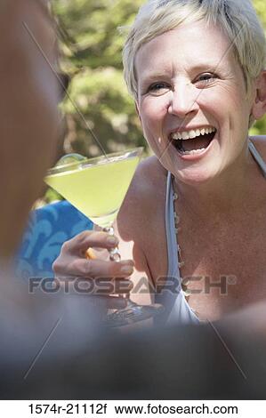 Close-up of a mature woman holding a martini and looking at a mature man View Large Photo Image Stock Image - Close-up of a mature woman holding a martini and looking at a mature man. Fotosearch