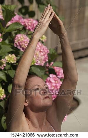 Close-up of a mature woman meditating in a tree pose View Large Photo Image Stock Photograph - Close-up of a mature woman meditating in a tree pose. Fotosearch