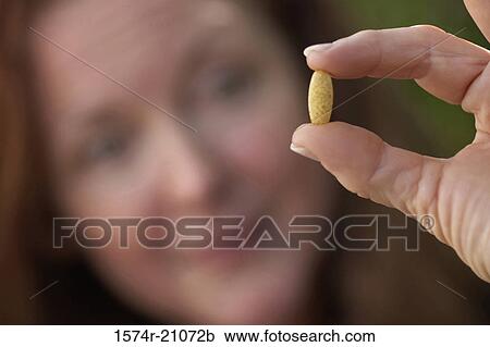 Close-up of a mature woman showing a pill View Large Photo Image Stock Image - Close-up of a mature woman showing a pill. Fotosearch