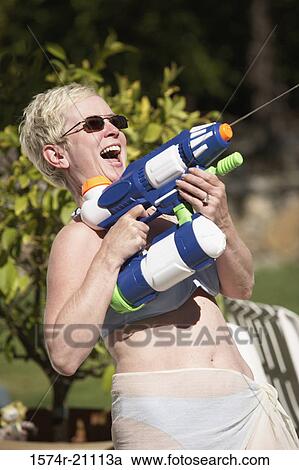 Close-up of a mature woman spraying water with a squirt gun View Large Photo Image Stock Image - Close-up of a mature woman spraying water with a squirt gun. Fotosearch
