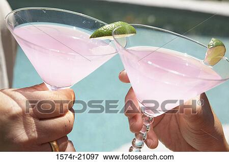 Close-up of two people's hands toasting with martini glasses View Large Photo Image Stock Photo - Close-up of two people's hands toasting with martini glasses. Fotosearch