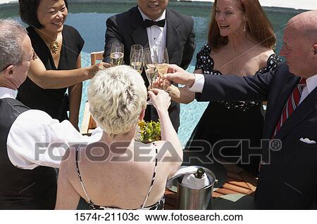 Stock Image - High angle view of three mature couples toasting with champagne flutes. Fotosearch