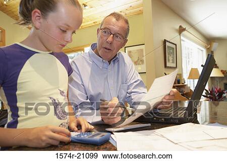 Mature man holding a document and his granddaughter using a calculator near him View Large Photo Image Stock Photo - Mature man holding a document and his granddaughter using a calculator near him. Fotosearch