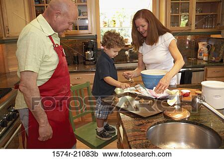 Side profile of a boy standing on a chair with his grandparents in the kitchen View Large Photo Image Stock Image - Side profile of a boy standing on a chair with his grandparents in the kitchen. Fotosearch
