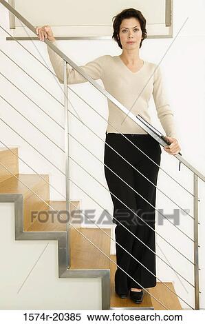Businesswoman standing on a staircase View Large Photo Image Stock Photography - Businesswoman standing on a staircase. Fotosearch