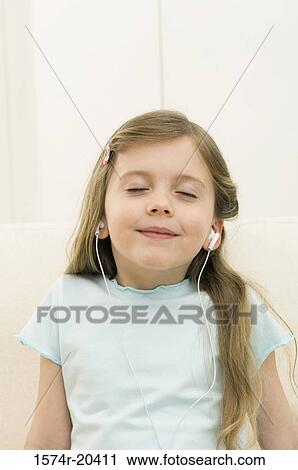 Close-up of a girl wearing headphones and listening to music View Large Photo Image Stock Image - Close-up of a girl wearing headphones and listening to music. Fotosearch