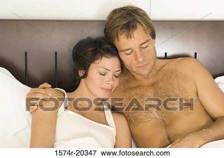 Close-up of a young couple sleeping in bed View Large Photo Image Stock Photo - Close-up of a young couple sleeping in bed. Fotosearch