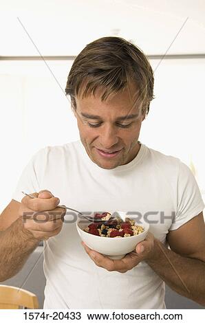 Close-up of a young man eating fruit salad View Large Photo Image Stock Image - Close-up of a young man eating fruit salad. Fotosearch