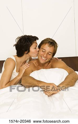 Close-up of a young woman kissing a young man's cheek View Large Photo Image Stock Photograph - Close-up of a young woman kissing a young man's cheek. Fotosearch
