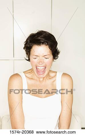 Close-up of a young woman shouting with her eyes closed View Large Photo Image Stock Photo - Close-up of a young woman shouting with her eyes closed. Fotosearch
