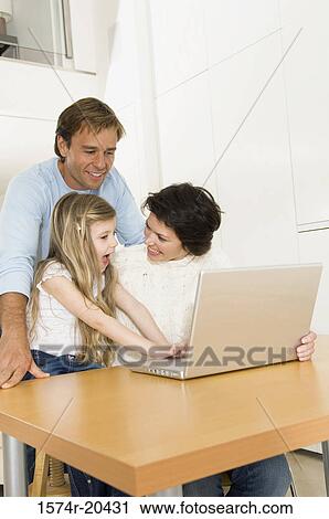 Girl using a laptop with her parents View Large Photo Image Stock Image - Girl using a laptop with her parents. Fotosearch
