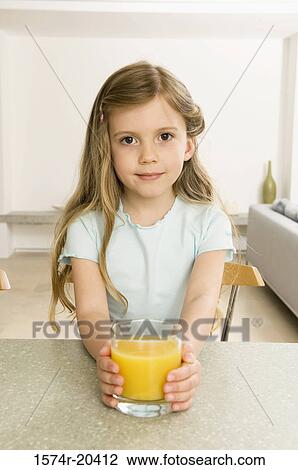 Portrait of a girl holding a glass of orange juice View Large Photo Image Stock Image - Portrait of a girl holding a glass of orange juice. Fotosearch