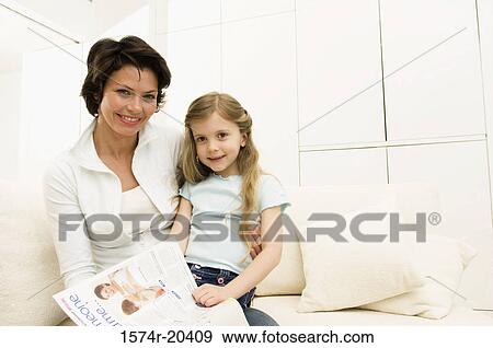 Portrait of a girl sitting on her mother's lap on a couch View Large Photo Image Stock Photo - Portrait of a girl sitting on her mother's lap on a couch. Fotosearch