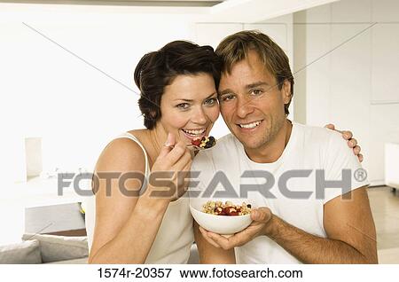 Portrait of a young couple eating fruit salad and smiling View Large Photo Image Stock Photo - Portrait of a young couple eating fruit salad and smiling. Fotosearch