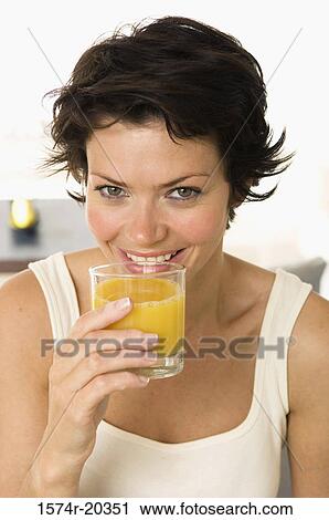 Portrait of a young woman drinking orange juice View Large Photo Image Stock Image - Portrait of a young woman drinking orange juice. Fotosearch