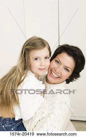 Portrait of a young woman smiling with her daughter View Large Photo Image Stock Photo - Portrait of a young woman smiling with her daughter. Fotosearch