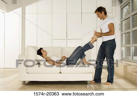 Side profile of a young man holding the foot of a young woman View Large Photo Image Stock Image - Side profile of a young man holding the foot of a young woman. Fotosearch