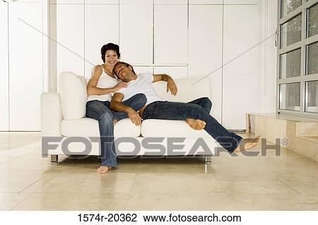 Young man leaning against a young woman sitting on a couch View Large Photo Image Stock Image - Young man leaning against a young woman sitting on a couch. Fotosearch