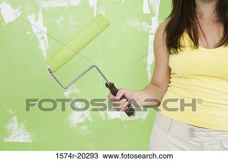 Close-up of a woman holding a paint roller View Large Photo Image Stock Image - Close-up of a woman holding a paint roller. Fotosearch