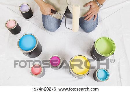 High angle view of a man holding a paint roller with paint cans in front of him View Large Photo Image Stock Photograph - High angle view of a man holding a paint roller with paint cans in front of him. Fotosearch