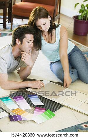 Stock Image - High angle view of a young couple with color swatches in front of them. Fotosearch