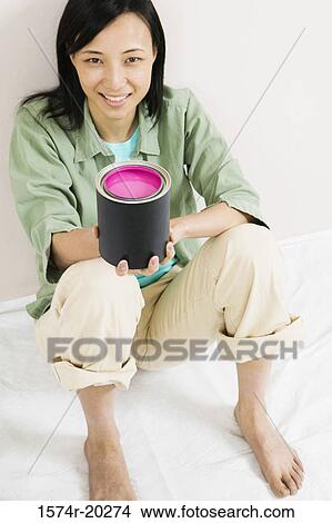 High angle view of a young woman holding a paint can View Large Photo Image Picture - High angle view of a young woman holding a paint can. Fotosearch