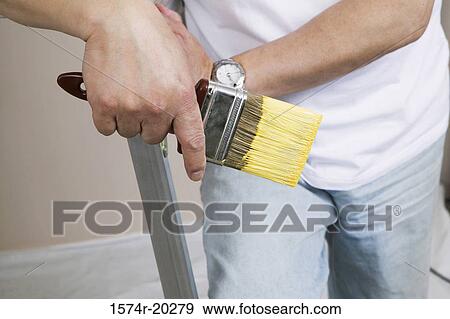 Mid section view of a man holding a paintbrush View Large Photo Image Stock Photo - Mid section view of a man holding a paintbrush. Fotosearch