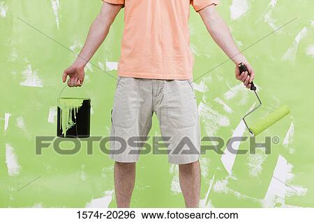 Mid section view of a man holding a paint can and a paint roller View Large Photo Image Stock Photograph - Mid section view of a man holding a paint can and a paint roller. Fotosearch