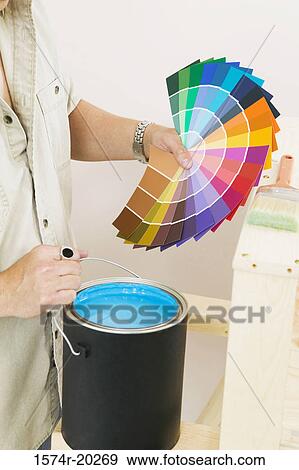 Mid section view of a man holding color swatches and a paint can View Large Photo Image Stock Photo - Mid section view of a man holding color swatches and a paint can. Fotosearch