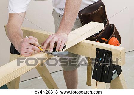 Mid section view of a man marking with a level on a plank View Large Photo Image Stock Image - Mid section view of a man marking with a level on a plank. Fotosearch