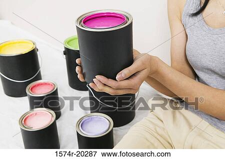 Mid section view of a woman holding a paint can View Large Photo Image Stock Photo - Mid section view of a woman holding a paint can. Fotosearch