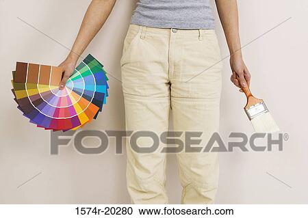 Mid section view of a woman holding color swatches and a paintbrush View Large Photo Image Stock Image - Mid section view of a woman holding color swatches and a paintbrush. Fotosearch