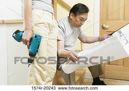 Mid section view of a young woman holding a drill with a mid adult man looking at a blueprint View Large Photo Image Stock Image - Mid section view of a young woman holding a drill with a mid adult man looking at a blueprint. Fotosearch