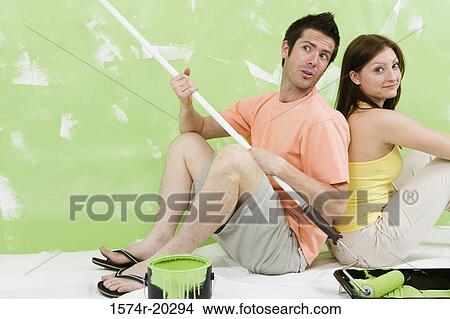 Portrait of a young couple sitting back to back on a drop sheet View Large Photo Image Picture - Portrait of a young couple sitting back to back on a drop sheet. Fotosearch