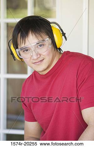 Stock Photography - Portrait of a young man wearing protective workwear. Fotosearch