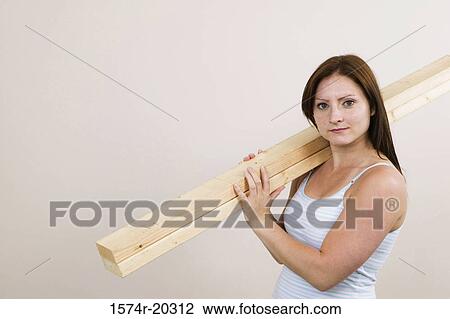 Portrait of a young woman carrying planks on her shoulders View Large Photo Image Stock Image - Portrait of a young woman carrying planks on her shoulders. Fotosearch