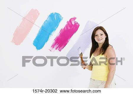 Portrait of a young woman holding a paintbrush View Large Photo Image Stock Image - Portrait of a young woman holding a paintbrush. Fotosearch