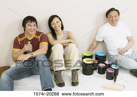 Portrait of a young woman sitting in between a young man and a mid adult man View Large Photo Image Stock Photo - Portrait of a young woman sitting in between a young man and a mid adult man. Fotosearch