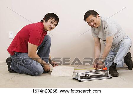 Side profile of a mid adult man and a young man measuring a tile with a tape measure View Large Photo Image Stock Photo - Side profile of a mid adult man and a young man measuring a tile with a tape measure. Fotosearch