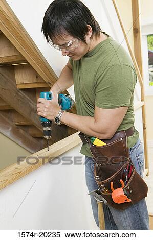 Side profile of a young man drilling into a plank View Large Photo Image Stock Photography - Side profile of a young man drilling into a plank. Fotosearch