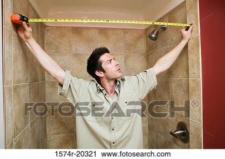 Young man measuring the width of the bathroom with a tape measure View Large Photo Image Stock Image - Young man measuring the width of the bathroom with a tape measure. Fotosearch