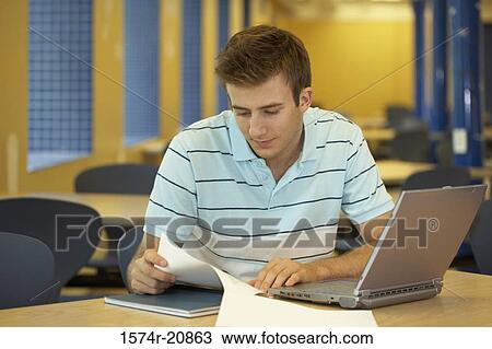 Stock Image - Close-up of a college student reading a paper. Fotosearch