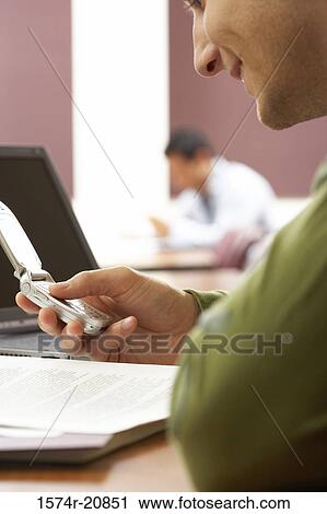 Close-up of a college student using a mobile phone and smiling View Large Photo Image Stock Image - Close-up of a college student using a mobile phone and smiling. Fotosearch