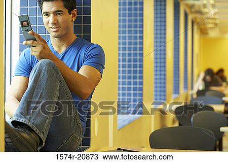 Stock Image - Close-up of a college student using a mobile phone. Fotosearch