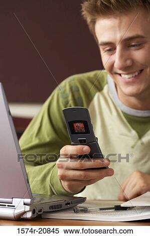 Close-up of a college student using a mobile phone and smiling View Large Photo Image Stock Photography - Close-up of a college student using a mobile phone and smiling. Fotosearch