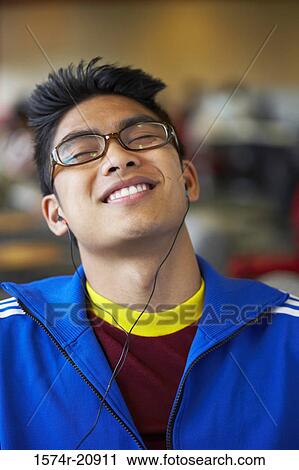 Stock Image - Close-up of a college student wearing headphones and listening to music. Fotosearch
