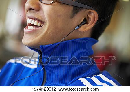 Close-up of a college student wearing headphones and listening to music View Large Photo Image Stock Image - Close-up of a college student wearing headphones and listening to music. Fotosearch