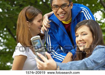 Close-up of three college students taking their picture with a mobile phone View Large Photo Image Stock Photo - Close-up of three college students taking their picture with a mobile phone. Fotosearch